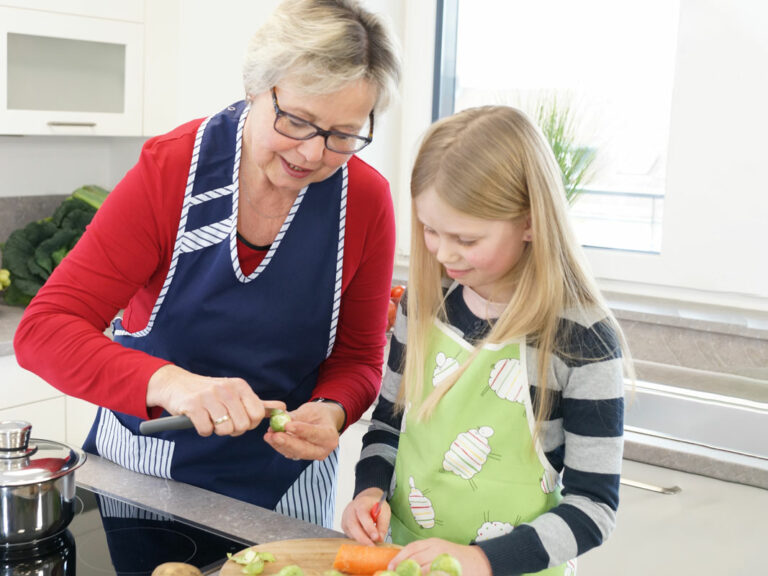 Haushaltshelferin mit Kind am kochen