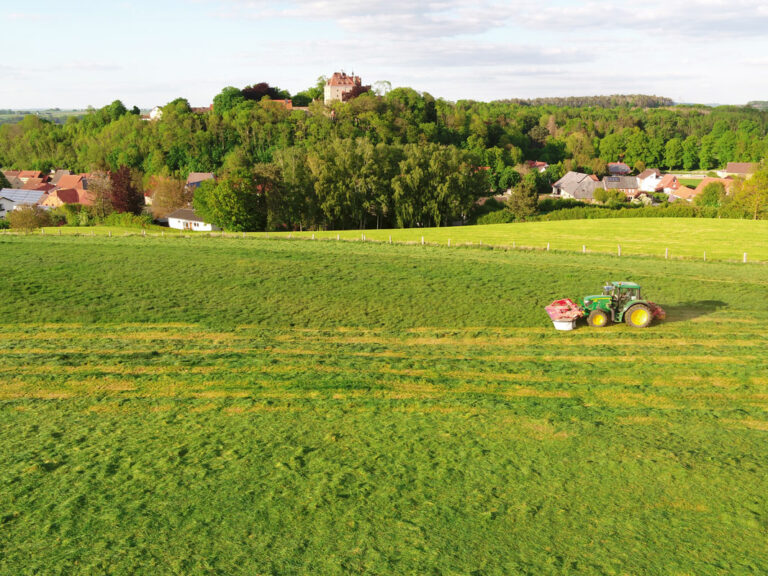 Ein Traktor von einem Mitglied des Maschinenrings Höxter beim Wiesen mähen.