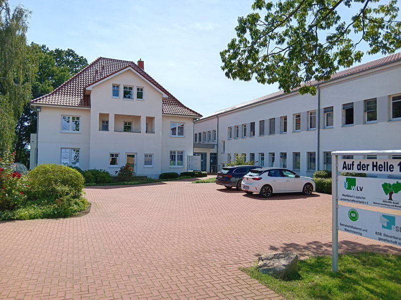 weißes renoviertes Haupthaus, rechts neuer weißer Bürobau