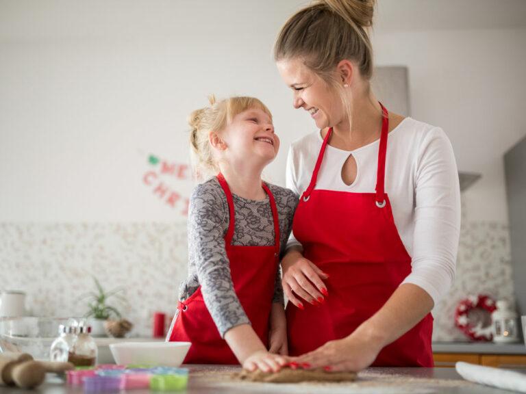 Haushaltshilfe betreut Kinder und backt einen Kuchen.